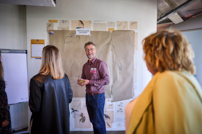 Mensen staan bij een presentatie van een pilot duurzame cao