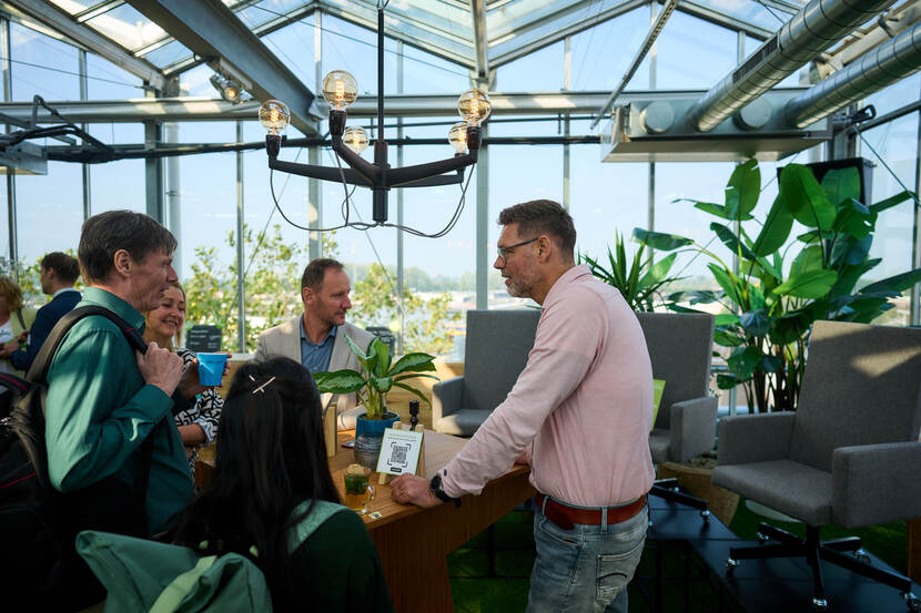 Mensen staan aan een tafel met elkaar te praten