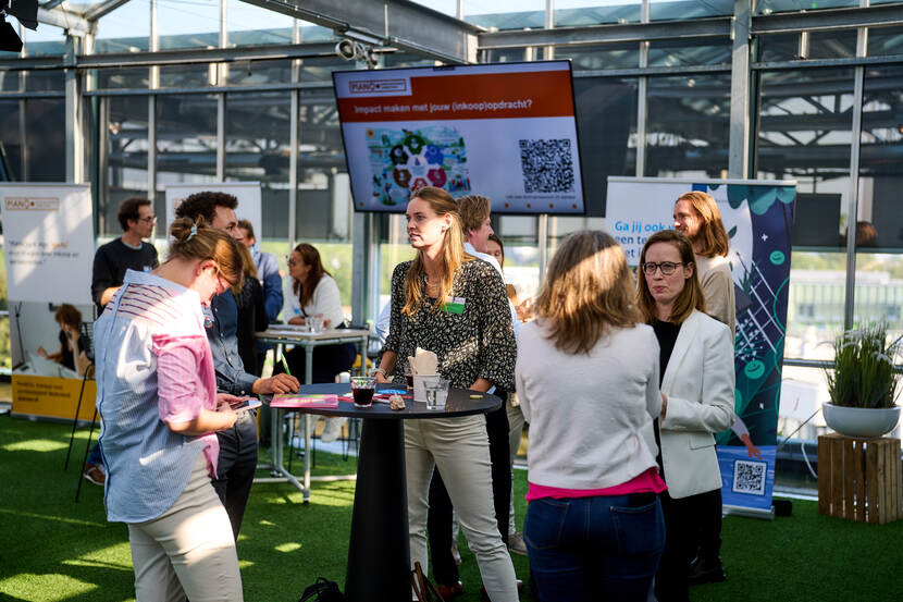 Mensen staan in groepjes met elkaar te praten